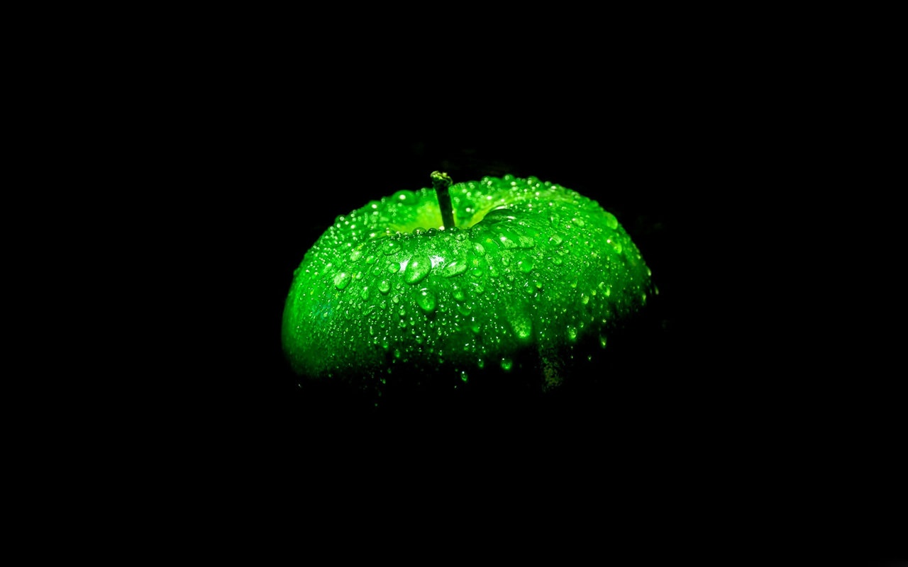 Green apple on black background