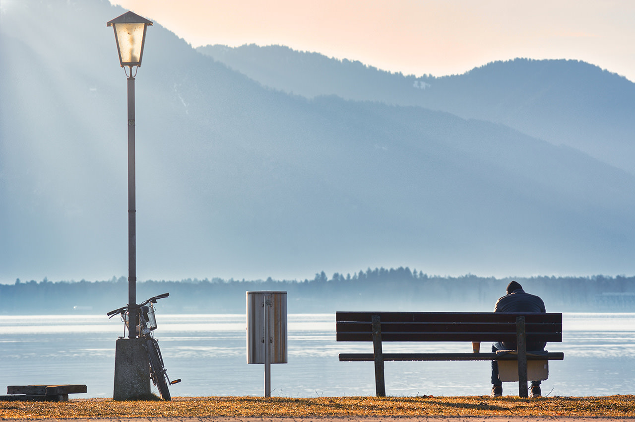 Man Sitting on a Lakeside's Bench